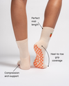 The Just Peachy Grip Sock by Revel Athletic, shown here on the model’s feet, features a cream midi length and an orange checkered non-slip sole. Labels highlight its perfect midi fit, full heel-to-toe grip coverage, and compression arch support—making these socks the ideal choice for Pilates, ensuring secure movement and lasting comfort all day long.