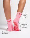 A person wearing The Miami Grip Sock by Revel Athletic stands on tiptoe. Text points out features: perfect midi length, heel-to-toe grip coverage, and compression arch support. The red non-slip grip pattern is visible on the pink soles with red stripes.