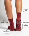 Wearing The Sweetheart socks by Revel Athletic, a person enjoys maroon crew-length GripGrid socks designed for Pilates, featuring arch support and heel-to-toe checkered grip with “revel” on the sole; they’re washer and dryer safe.