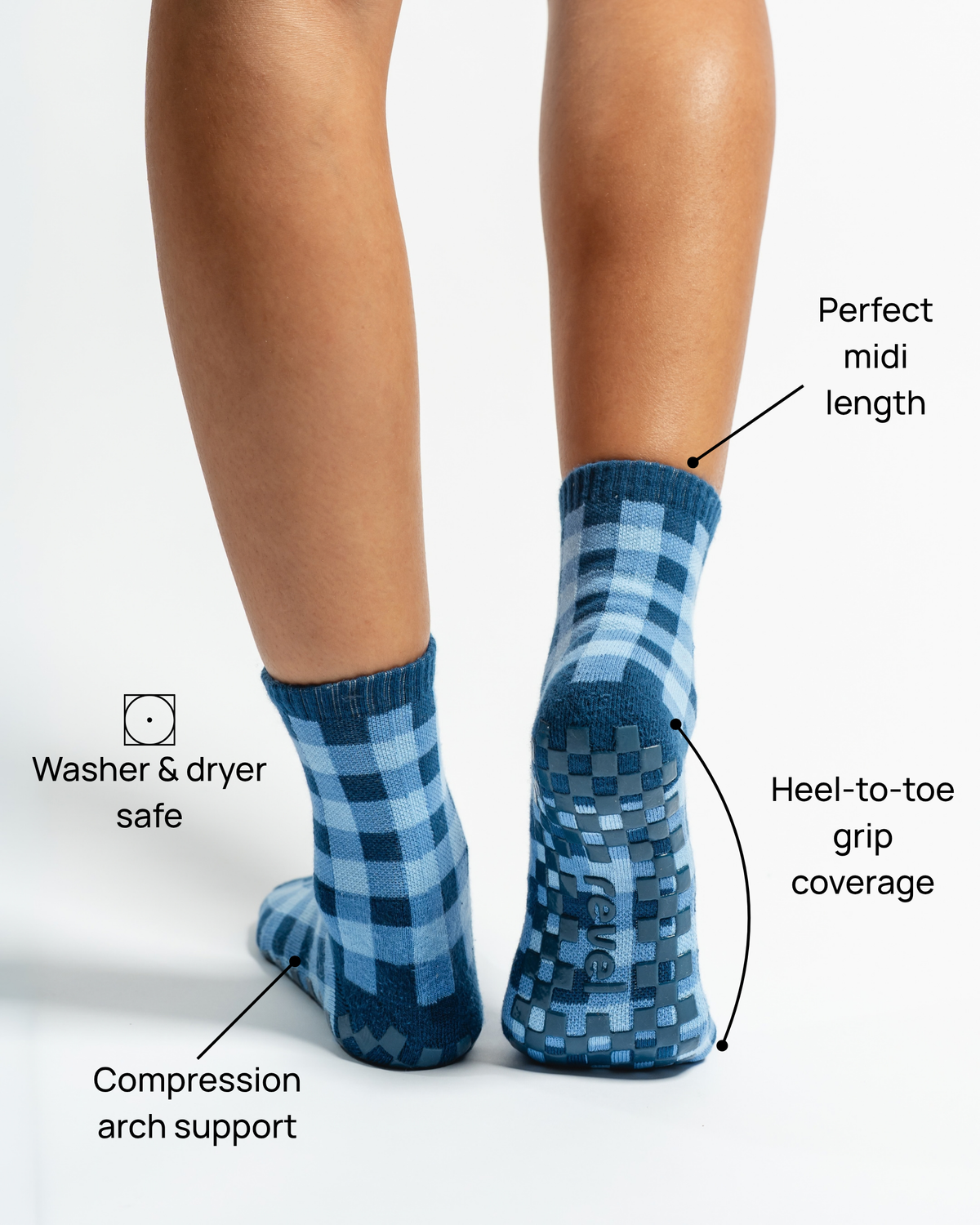 A person is seen from behind wearing The Prep Grip Sock by Revel Athletic in blue gingham. These midi-length socks are washer and dryer safe, offer compression arch support, and provide heel-to-toe grip coverage—making them perfect as barre or pilates grip socks for your next studio session.