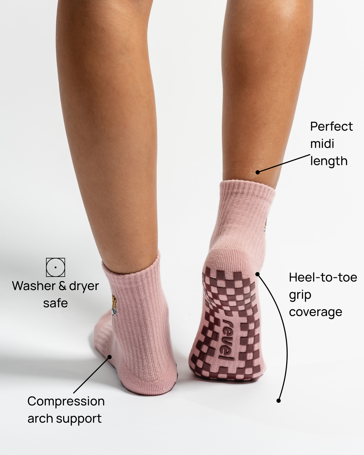 Wearing The Wildcat Grip Sock by Revel Athletic in pink with leopard embroidery, this person enjoys washer & dryer safe construction, compression arch support, a perfect midi length, and full heel-to-toe grip coverage. Featuring a non-slip grid pattern on the sole, these Pilates essentials blend stylish design with practical performance.