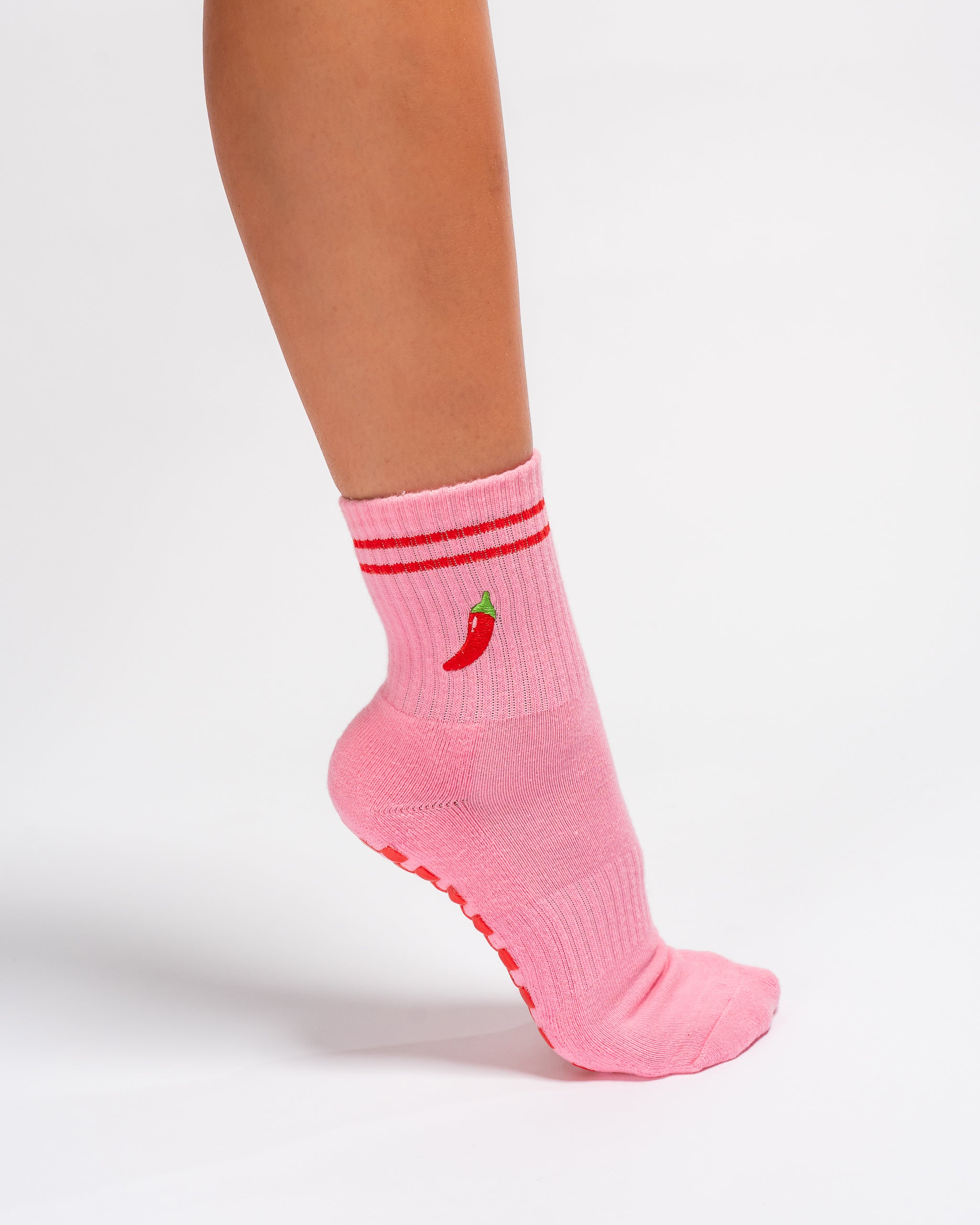 Pink Miami grip socks with red stripes, chili pepper embroidery, and a red non-slip traction sole