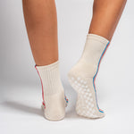 Cream Chicago grip socks with vertical red and blue side stripes and a white non-slip patented grip sole