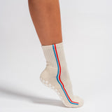 Cream Chicago grip socks with vertical red and blue side stripes and a white non-slip patented grip sole