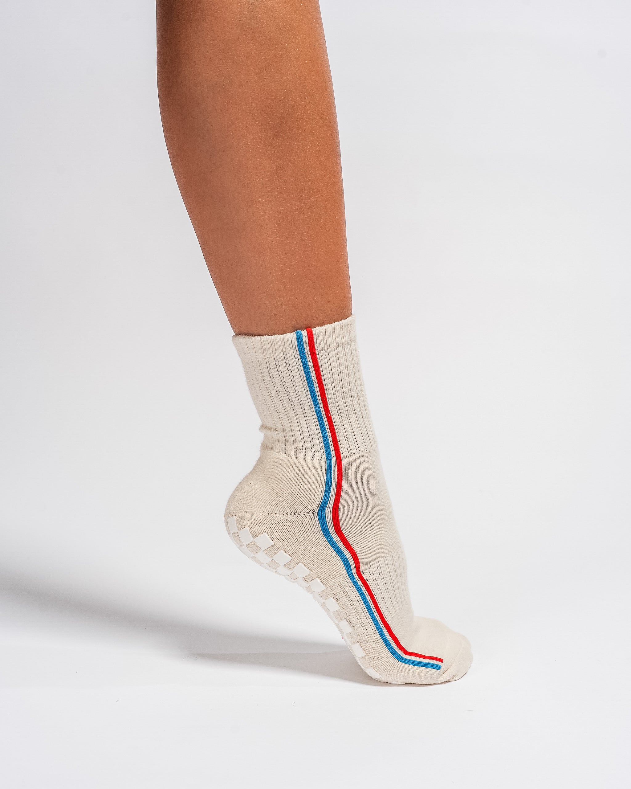 Cream Chicago grip socks with vertical red and blue side stripes and a white non-slip patented grip sole