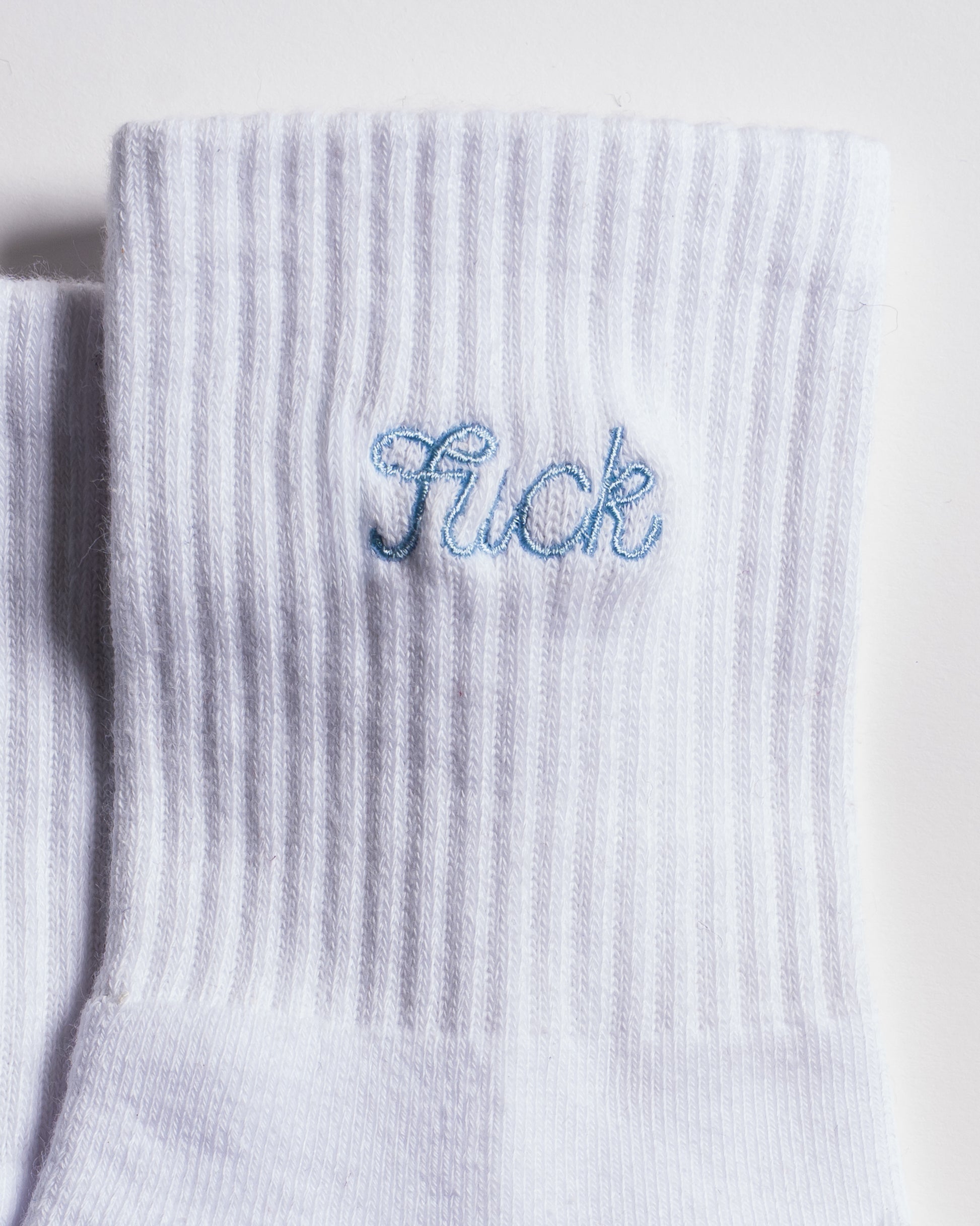The Pardon My French Grip Sock (Baby Blue) by Revel Athletic features a white ribbed design with “Sick” embroidered in light blue near the cuff, making it perfect as Pilates or barre grip socks for your next studio session.