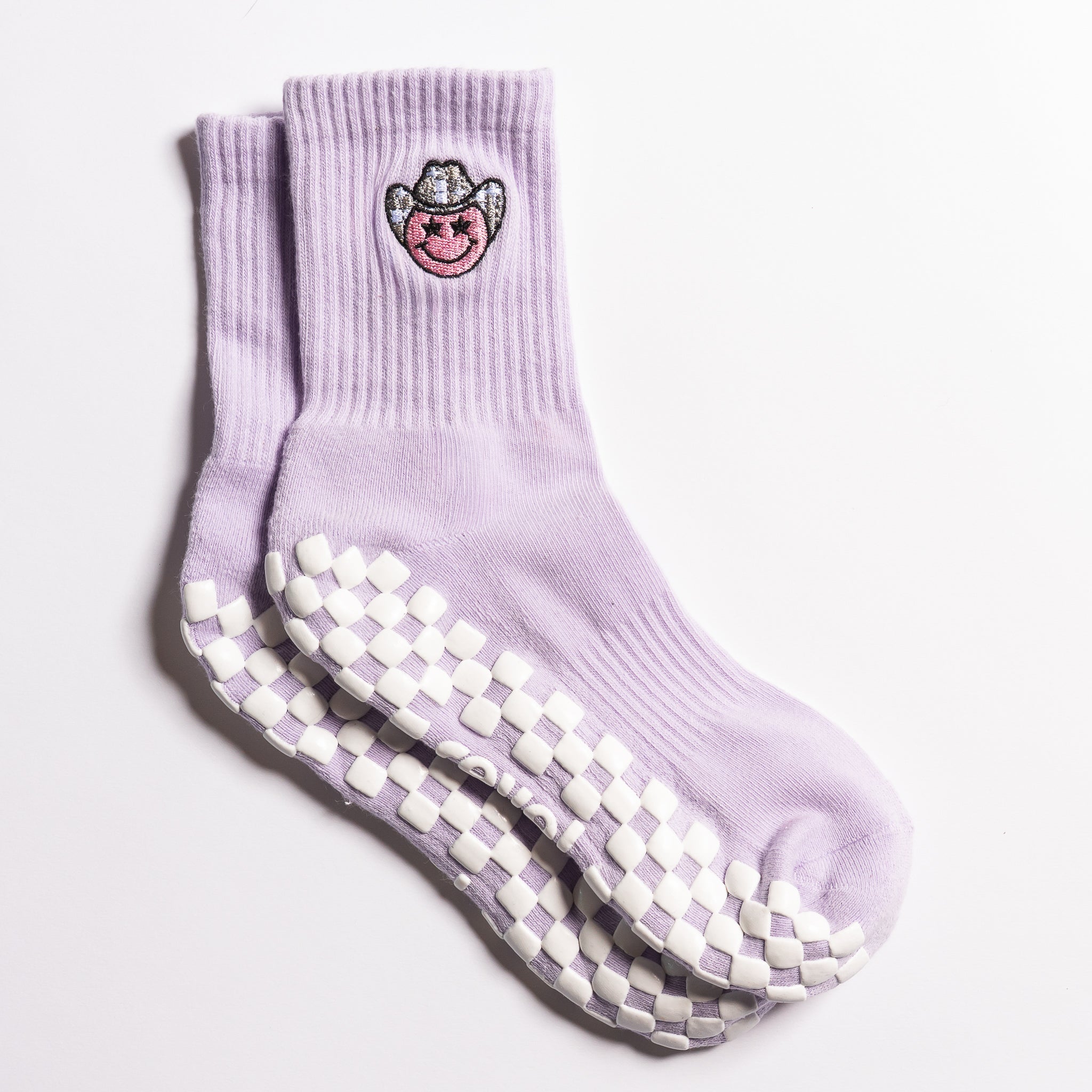 Lavender Austin grip socks with a cowboy-hat smiley face embroidery and a white non-slip traction sole