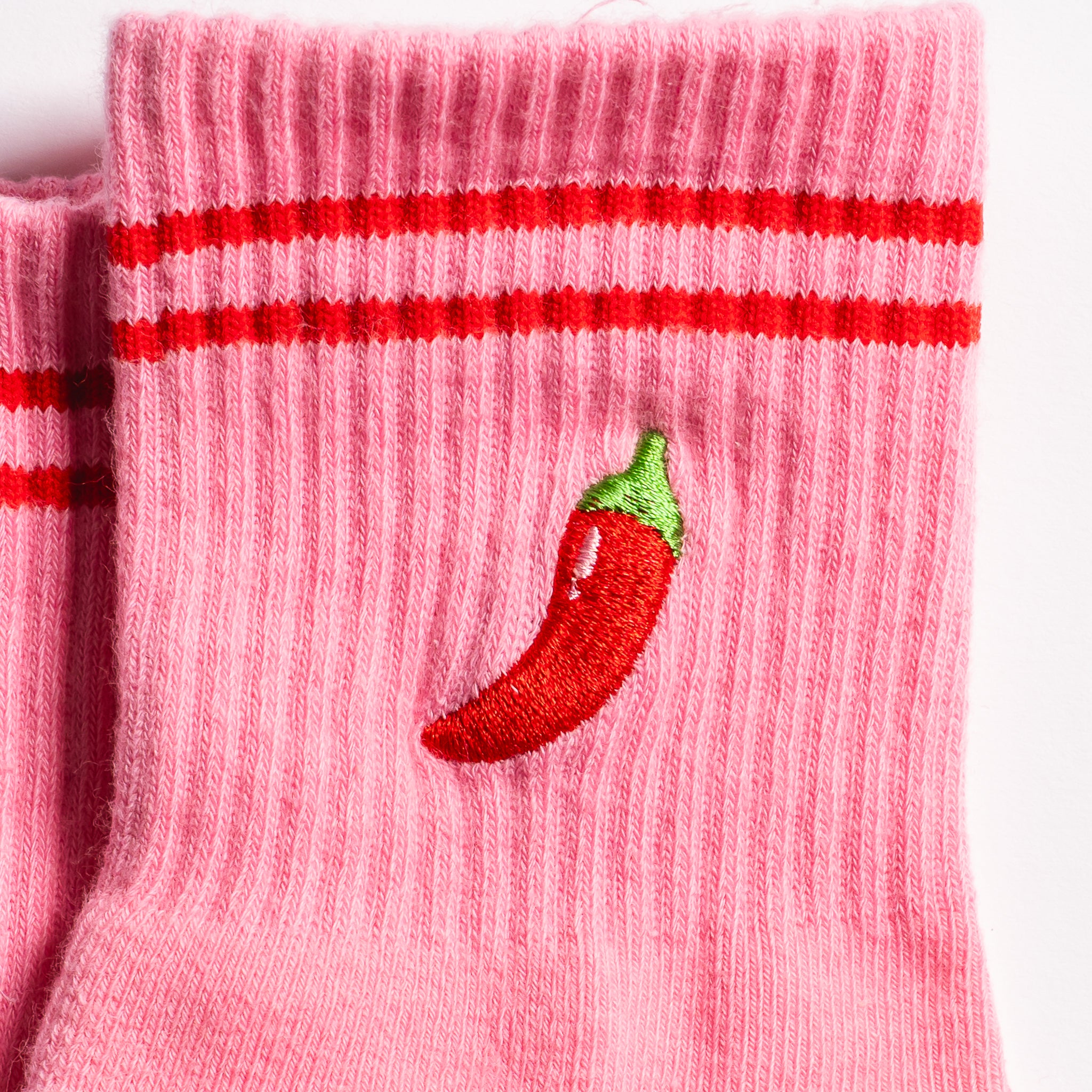 Pink Miami grip socks with red stripes, chili pepper embroidery, and a red non-slip traction sole