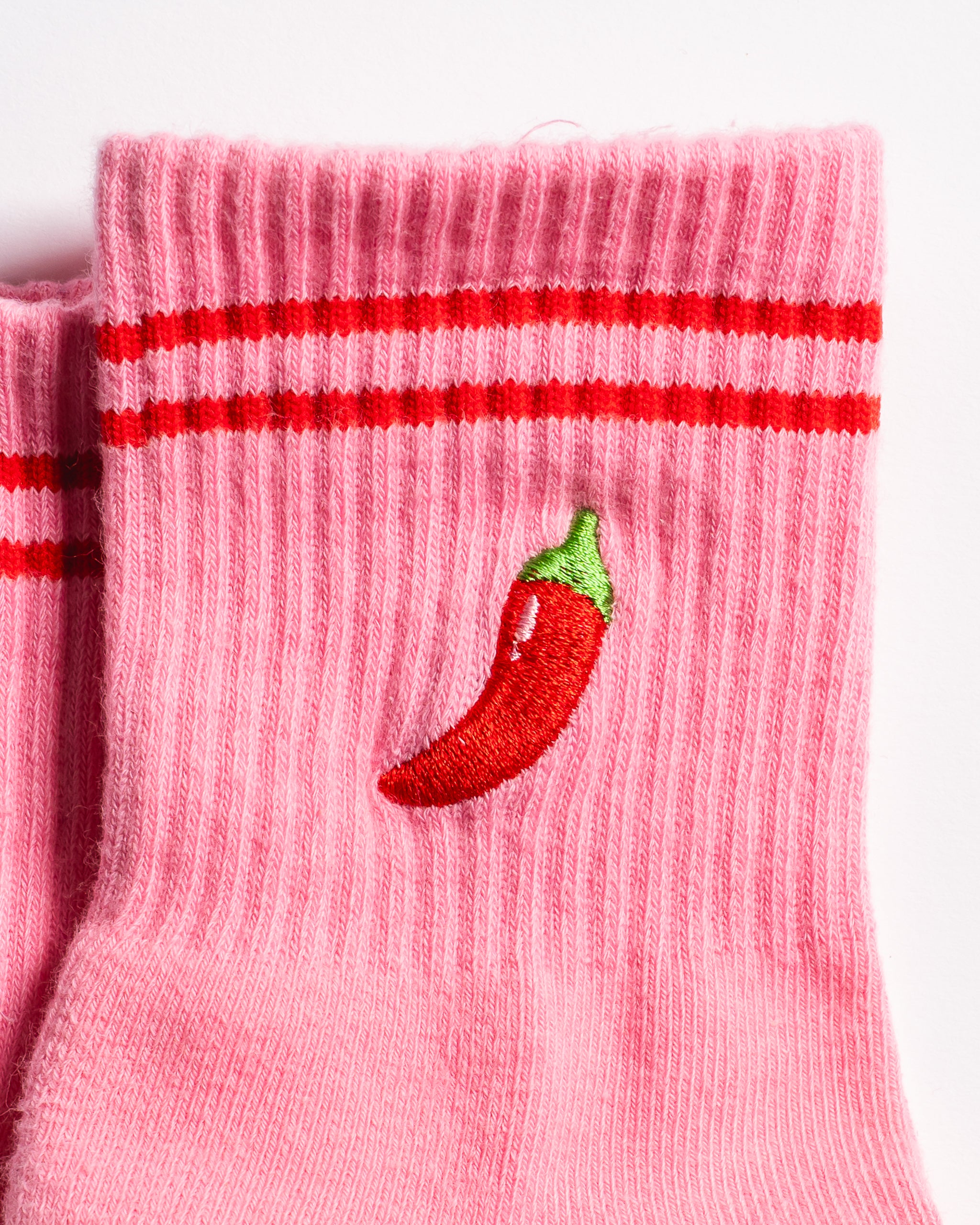 Pink Miami grip socks with red stripes, chili pepper embroidery, and a red non-slip traction sole