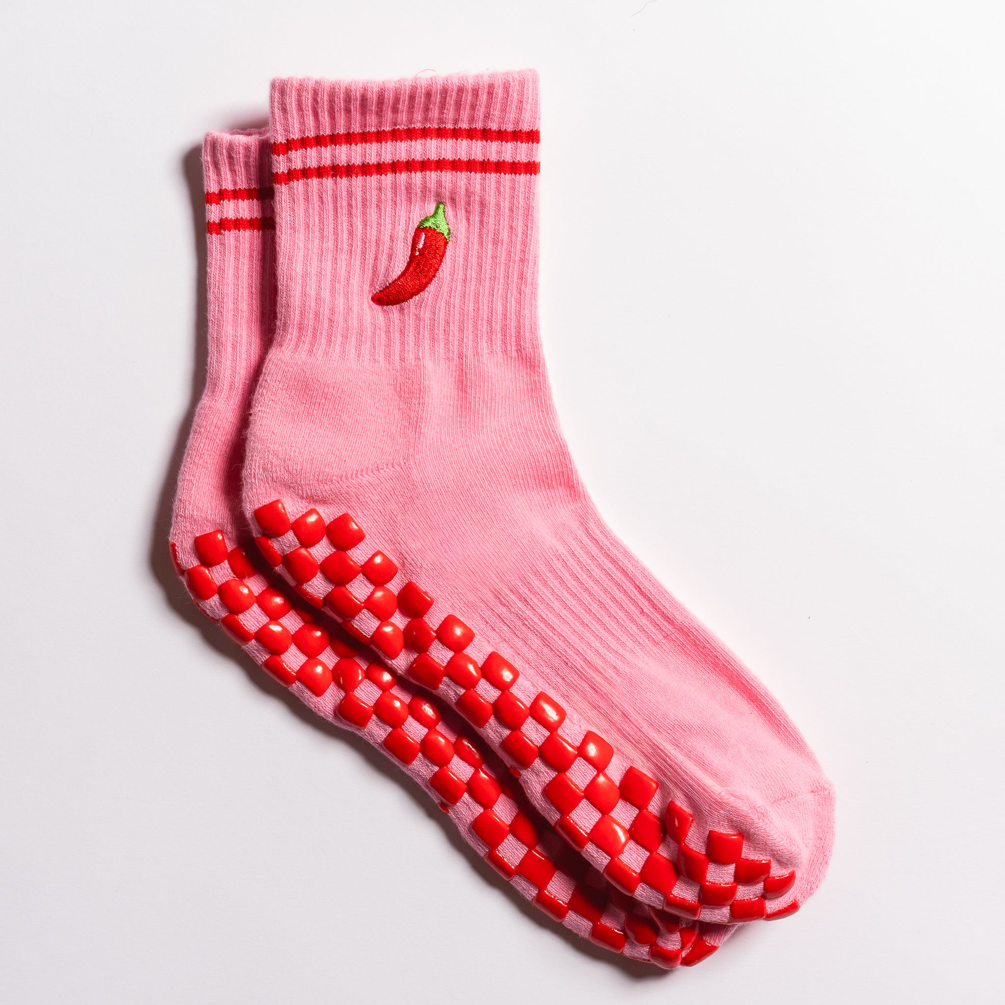 Pink Miami grip socks with red stripes, chili pepper embroidery, and a red non-slip traction sole