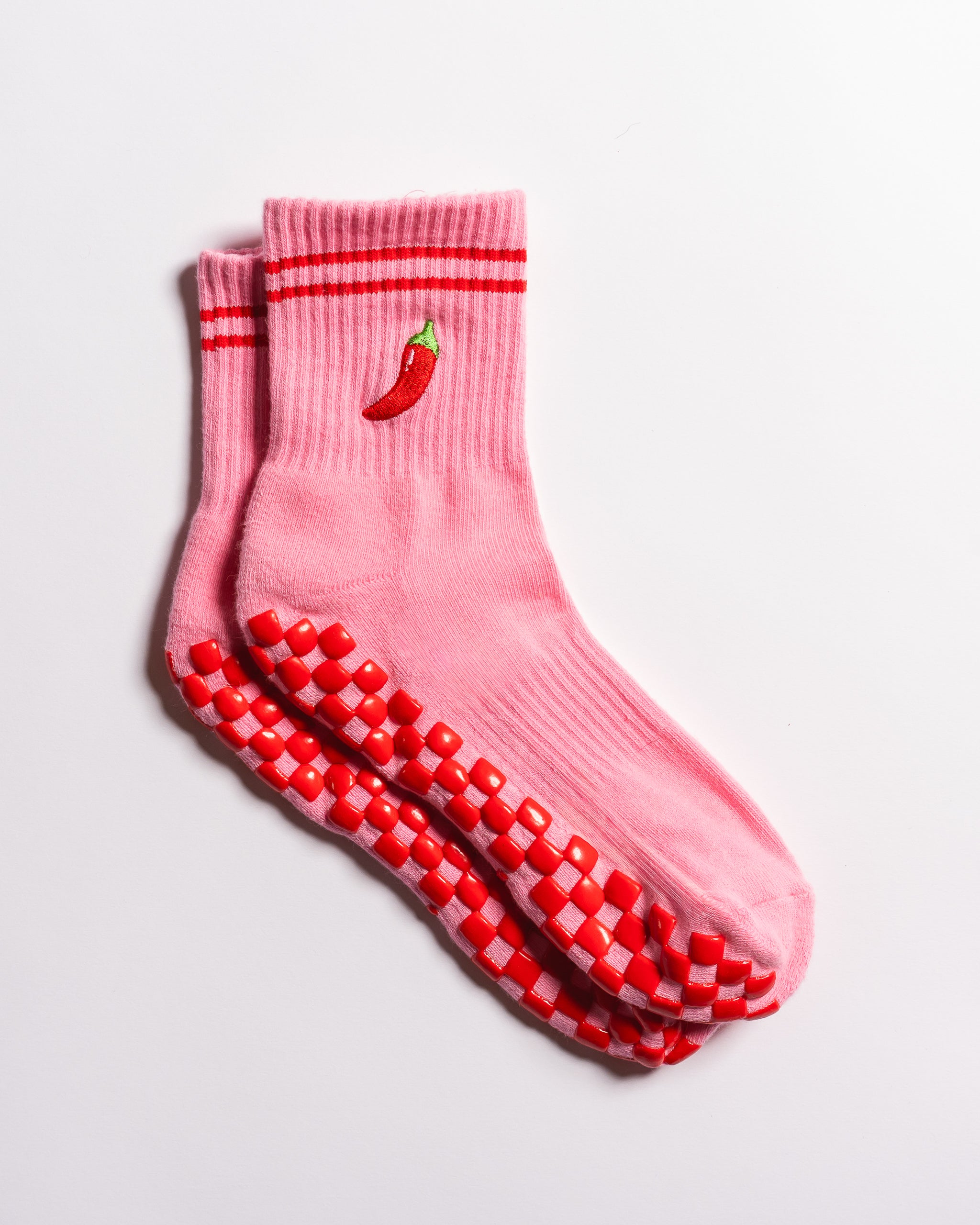 Pink Miami grip socks with red stripes, chili pepper embroidery, and a red non-slip traction sole