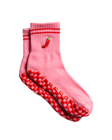 A pair of pink grip socks with red stripes at the top, a small red chili pepper embroidered on the side, and red and white grip dots on the soles—perfect for barre or pilates classes.