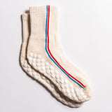 Cream Chicago grip socks with vertical red and blue side stripes and a white non-slip patented grip sole