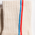Cream Chicago grip socks with vertical red and blue side stripes and a white non-slip patented grip sole
