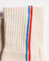Cream Chicago grip socks with vertical red and blue side stripes and a white non-slip patented grip sole