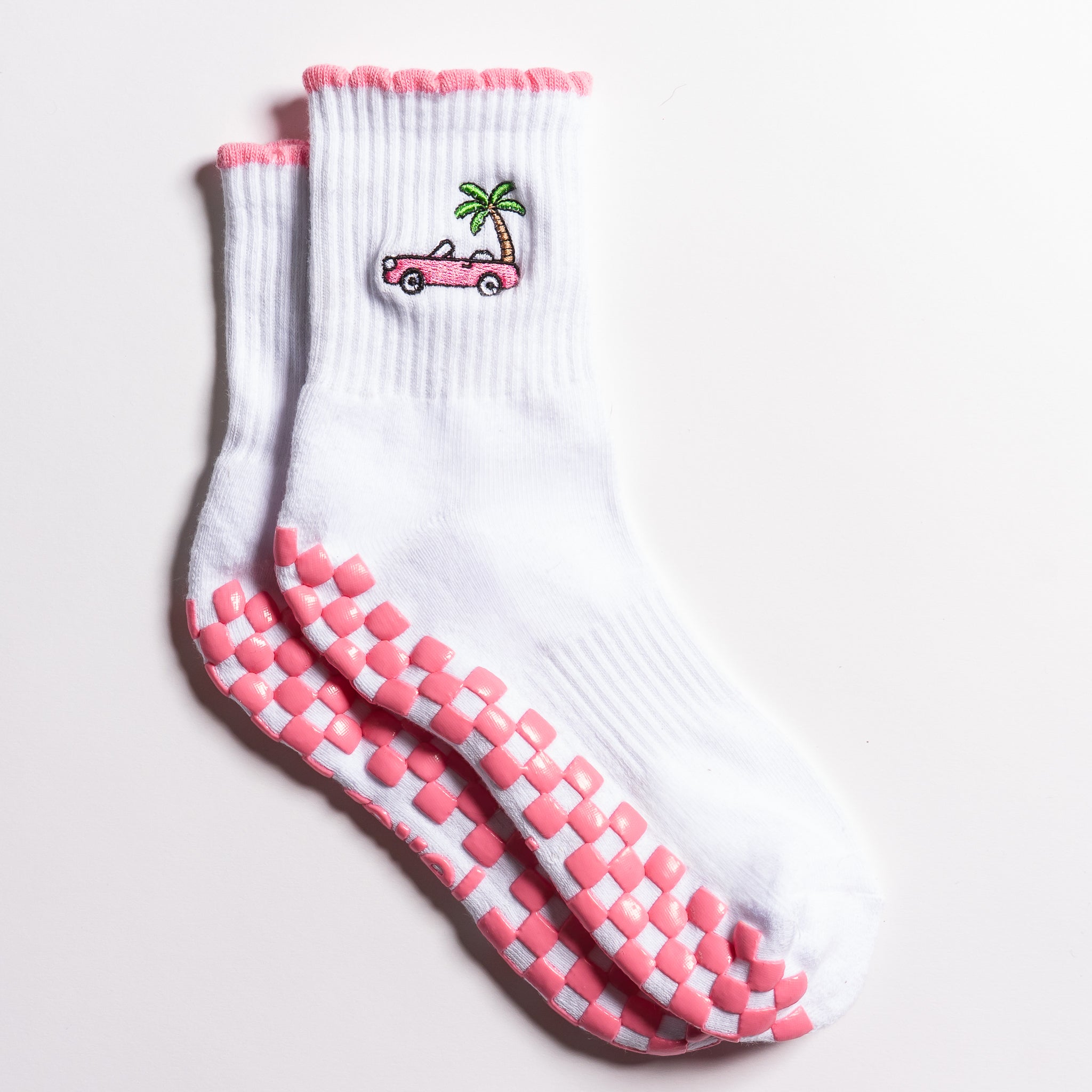 White Los Angeles grip socks with a pink scalloped cuff, pink convertible and palm-tree embroidery, and a pink non-slip patented grip sole
