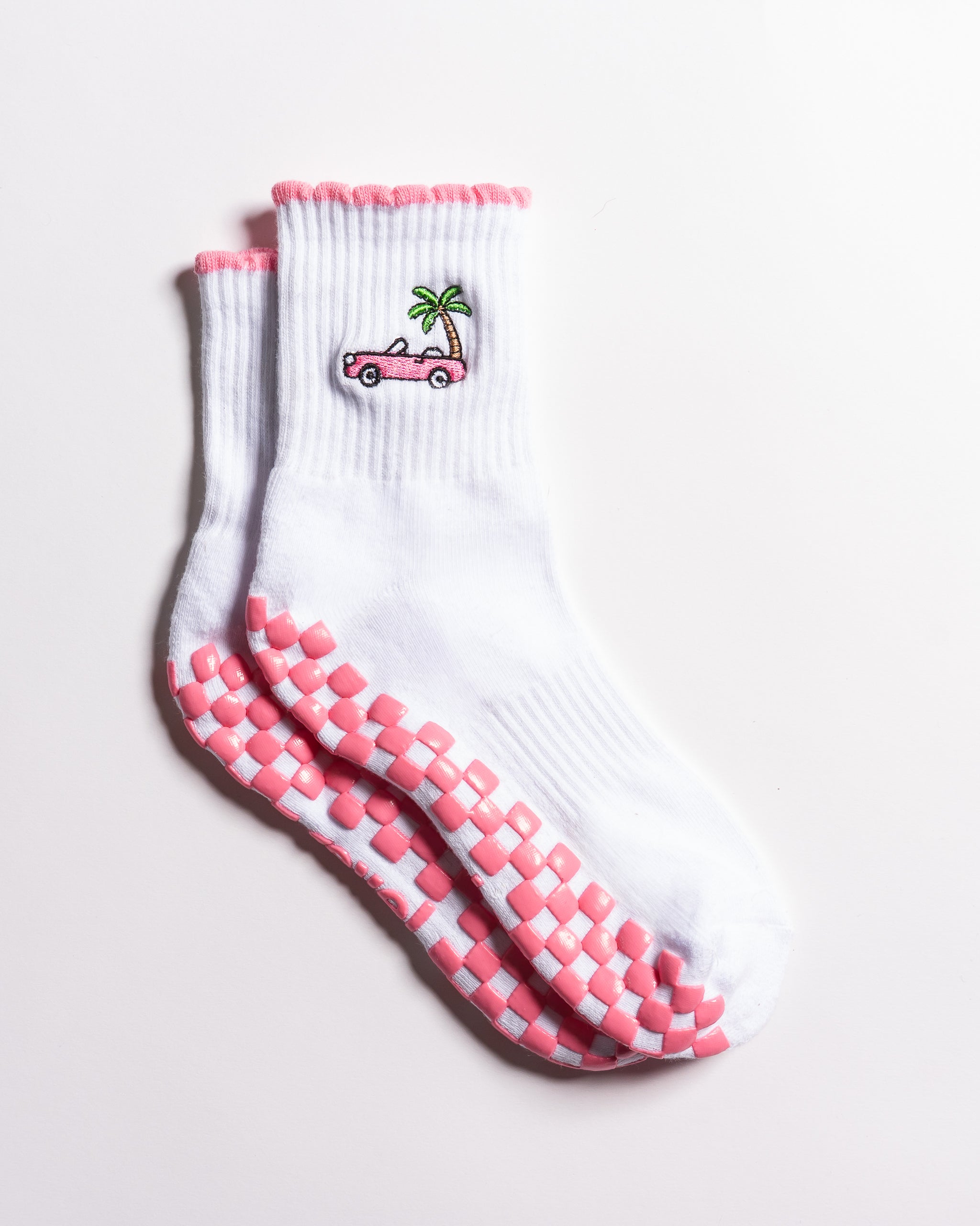 White Los Angeles grip socks with a pink scalloped cuff, pink convertible and palm-tree embroidery, and a pink non-slip patented grip sole