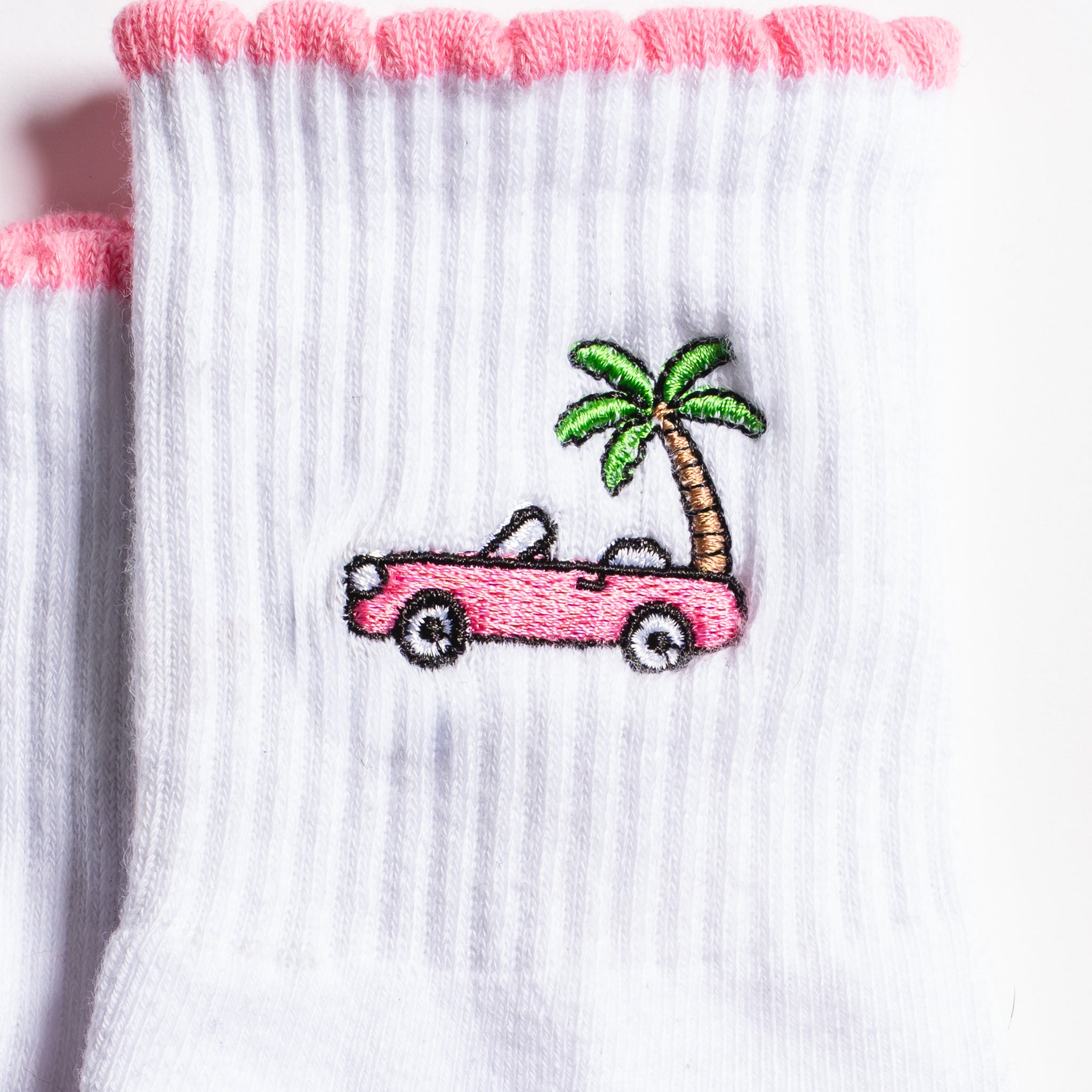 White Los Angeles grip socks with a pink scalloped cuff, pink convertible and palm-tree embroidery, and a pink non-slip patented grip sole