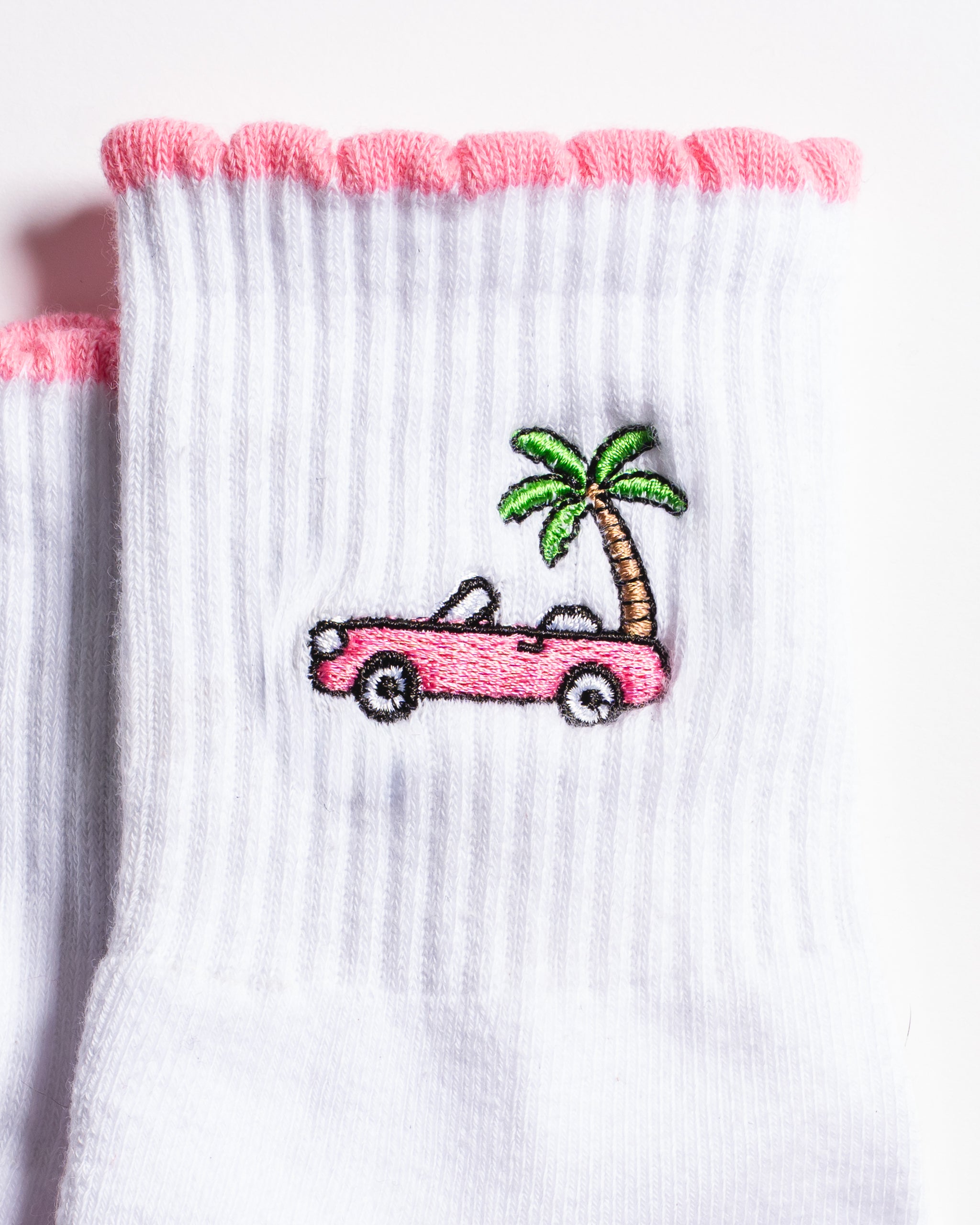 White Los Angeles grip socks with a pink scalloped cuff, pink convertible and palm-tree embroidery, and a pink non-slip patented grip sole