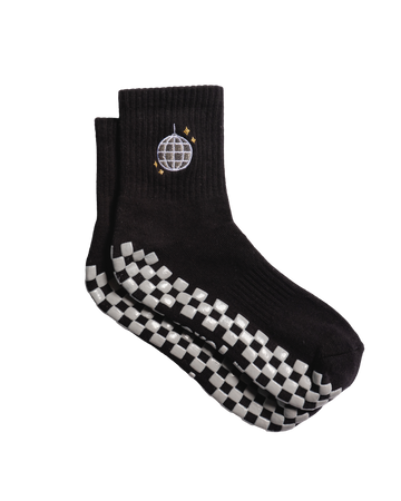 A pair of black grip socks featuring a disco ball and stars design near the ankle, with a white-and-black checkerboard pattern on the soles—perfect for pilates or barre classes.