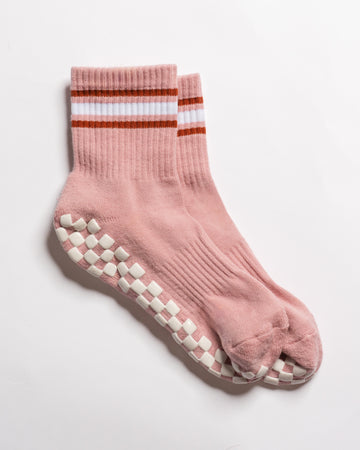 The Rally pink crew socks featuring retro court style, with white and rust-colored stripes at the cuff and white square GripGrid soles.