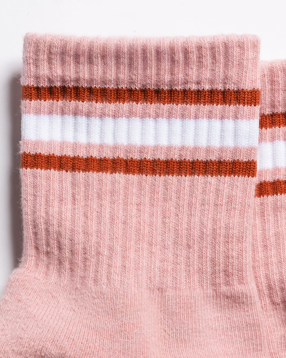 The Rally ribbed pink retro court style crew socks featuring two brown stripes and one central white stripe around the cuff by Revel Athletic.