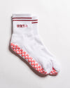 White The Sportyish crew socks by Revel Athletic featuring two maroon stripes at the cuff, the word SPORTYish embroidered in maroon, and pink grip pads on the soles.