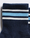 Revel Athletic The MVP navy blue yoga grip socks with white and light blue stripes around the ribbed cuff.