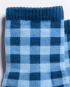 Close-up of The Prep Grip Sock by Revel Athletic in blue gingham. Featuring a ribbed cuff and alternating squares in two shades, these socks showcase a classic plaid design that’s perfect for elevating your everyday style.
