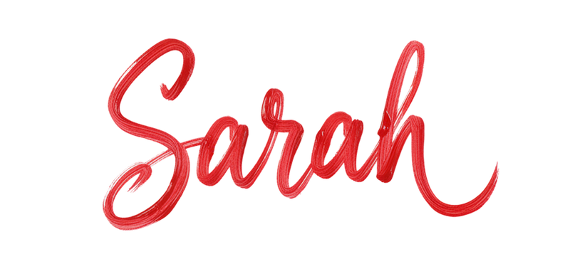 The name Sarah written in red cursive brushstroke lettering on a white background, resembling the playful pattern often found on cozy grip socks.